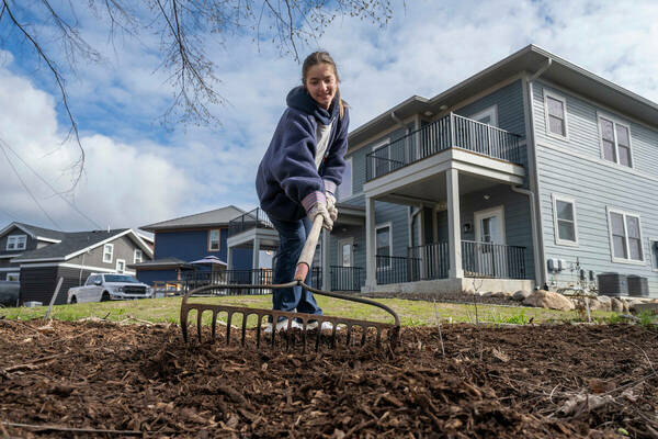 Notre Dame student Ella Trigiani rakes mulch in the backyard of a home in South Bend as part of Mulch Madness (Photo by Barbara Johnston/Notre Dame)