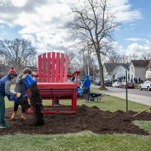 Notre Dame students spread mulch around the 12-foot Adirondack chair at Portage Avenue and Cushing Street in South Bend